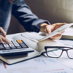 Close up of woman using a calculator at her desk