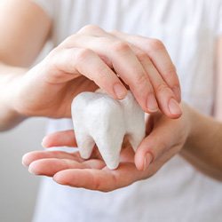 Close up of patient holding a giant model tooth