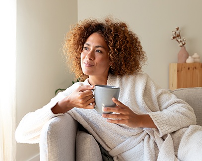 Woman resting at home, holding a beverage