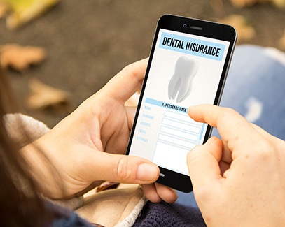 A woman checking her dental insurance on her phone