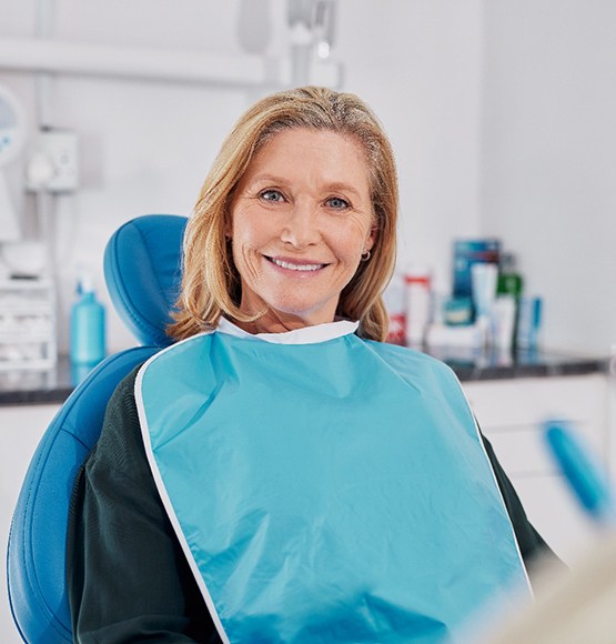 Older woman sitting in dental chair and smiling